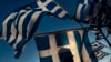 A pro-euro demonstrator is silhouetted behind a Greek flag during a rally outside the Greek Parliament in Athens, June 22, 2015.