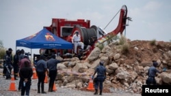 Miembros de la policía sudafricana patrullan mientras protegen el pozo de la mina donde se llevan a cabo operaciones de rescate mientras se intenta rescatar a mineros ilegales que han estado bajo tierra durante meses en Stilfontein, Sudáfrica, el 14 de enero de 2025.