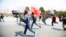 Members of a splinter faction of the Unified Communist Party of Nepal Maoist run and shout slogans as they protest against the formation of an interim government in Katmandu, Nepal, March 14, 2013.