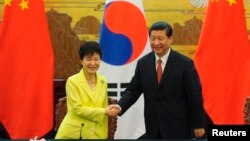 Presiden Korea Selatan Park Geun-Hye (kiri) berjabat tangan dengan Presiden China Xi Jinping (kanan) seusai upacara deklarasi kerjasama bilateral di Beijing (27/6). 