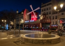 Streets are empty in front of the Moulin Rouge as a 7 p.m curfew starts in Paris, March 20, 2021.