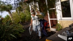 Annette Lowestein, from Germany, collects some of her belongings while leaving her house stalked by the lava that advances towards her neighborhood on the Canary island of La Palma, Spain, Oct. 30, 2021. 