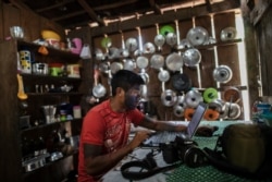 Local photographer Orerero Tembe edits his coverage of a meeting of the Tembe tribes in the Tekohaw village, in Para state, Brazil, Sept. 4,2019.