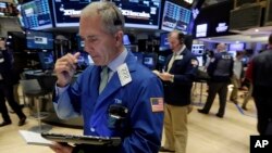 Trader Timothy Nick, left, works on the floor of the New York Stock Exchange, March 8, 2016. 