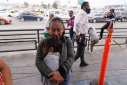 Lizeth Morales, of Honduras, hugs the daughter of a Honduran friend she met at a camp for migrant families as she waits to cross into the United States to begin the asylum process, July 5, 2021, in Tijuana, Mexico.