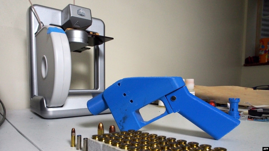 
Sebuah pistol Liberator tampak di sebelah pencetak 3-Dimensi yang mencetak komponen pistol, 11 Juli 2013.
