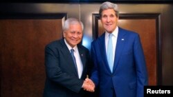 FILE - Foreign Minister of the Philippines Albert del Rosario (L) and U.S. Secretary of State John Kerry shake hands before a meeting.