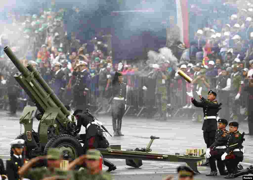 Seorang anggota unit artileri Meksiko menangkap selongsong meriam selama parade militer untuk merayakan Hari Kemerdekaan di Lapangan Zocalo di Mexico City.