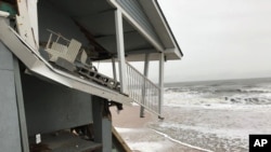 In this Jan. 3, 2018 photo, an unoccupied beachfront home collapses due to beach erosion in Ponte Vedra Beach, Florida. No one was injured. Several homes along the northeast Florida coast collapsed during Hurricane Irma in September. 