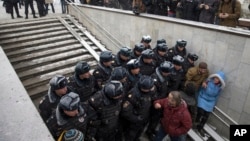 Police officers on a stairway block the path of people intending to attend an opposition rally in Pushkin Square in Moscow, Russia, Dec. 12, 2015.