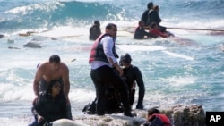 Penjaga pantai Yunani menyelamatkan para imigran yang kapalnya terdampar di lepas pantai Pulau Rhodes, Laut Aegean, Senin (20/4).