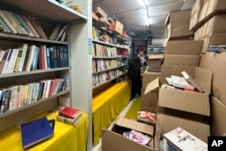 Boxes filled with books are seen inside the shuttered secondhand bookstore Wang Pangzi in Ningbo, in eastern China's Zhejiang province, Oct. 9, 2024.