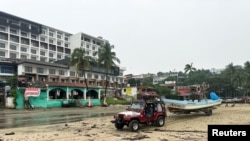 Un jeep arrastra un barco pesquero hacia la Capitanía del Puerto después de ser sacado del agua antes de la llegada de la tormenta John, en Puerto Escondido, estado de Oaxaca, México, el 23 de septiembre de 2024.