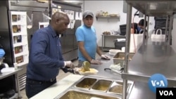 Minneapolis restaurant owner Abdirahman Kahin, left, packs some meals for delivery.his kitchen open to help feed people in need.