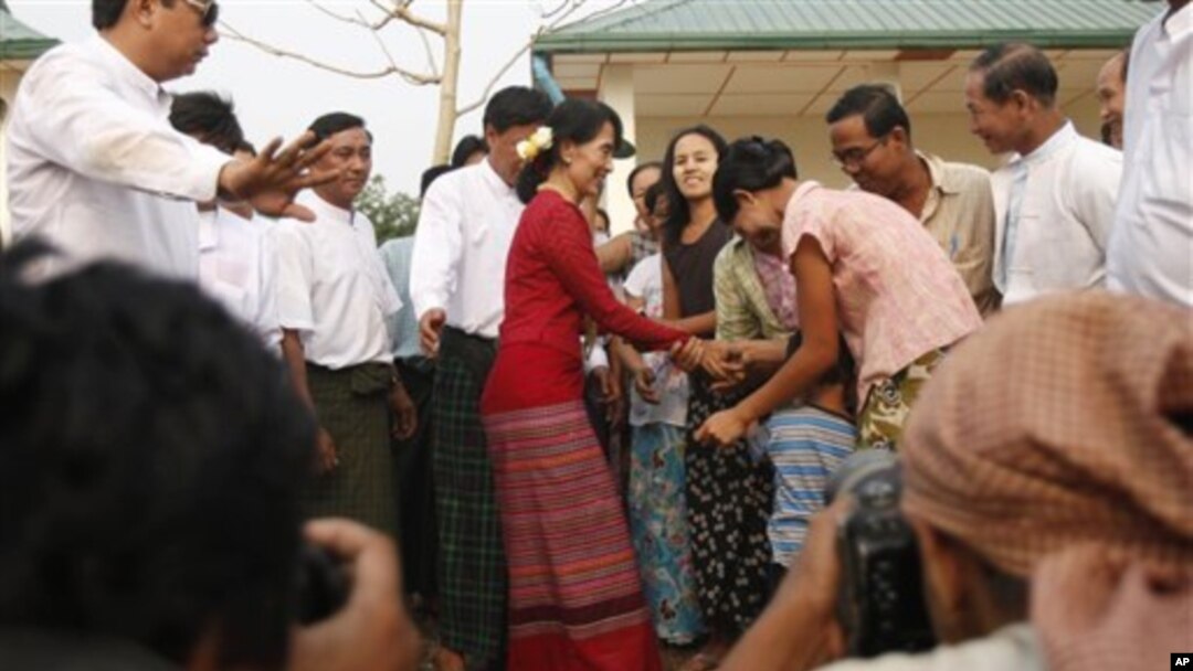 Tokoh demokrasi Burma, Aung San Suu Kyi (baju merah) disambut para pendukungnya saat mengunjungi TPS di pinggiran Rangoon (1/4).