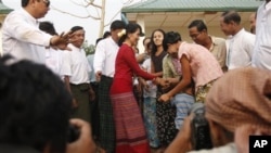 Tokoh demokrasi Burma, Aung San Suu Kyi (baju merah) disambut para pendukungnya saat mengunjungi TPS di pinggiran Rangoon (1/4).