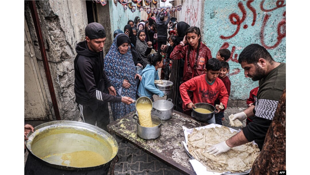 Pengungsi Palestina mengantre untuk menerima makanan yang disumbangkan oleh organisasi amal menjelang buka puasa di Rafah di Jalur Gaza selatan pada 16 Maret 2024. (Foto: AFP)