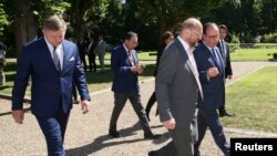 Le président François Hollande marche près du président du parlement européen Martin Schulz avant une réunion avec les chefs des partis démocrates au château de La Celle Saint-Cloud, près de Paris, le 25 août 2015.