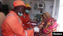 National Emergency Management Agency workers attend to a woman after suicide bombers detonated their explosives in Maiduguri, Nigeria, March 15, 2017. 