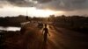 A boy stands on a road at dawn in Freetown, Sierra Leone, November 2012.