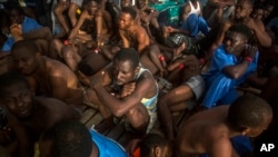 FILE - Migrants sit on the deck of a Proactiva Open Arms vessel after being rescued in the Mediterranean Sea, about 15 miles north of Sabratha, Libya, July 25, 2017. 