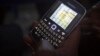 FILE - A voter in Kano looks for election figures on his smartphone, March 30, 2015. 