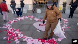 Demonstrators gathering in support of federal workers spread Valentine's Day-themed messages for them outside of the Department of Health and Human Services in Washington, Feb. 14, 2025.