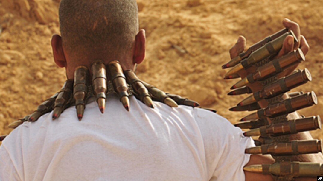 A rebel fighter carries large caliber ammunition on the front line, 18 km (11 miles) west of Ajdabiyah, Libya, June 27, 2011