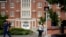 FILE - In this Sept. 18, 2015, photo, a University of Connecticut student pushes a button at a crosswalk outside a dormitory, in Storrs, Conn. 