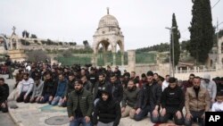 FILE—Palestinian Muslim worshipers who were prevented from entering the Al-Aqsa Mosque compound, pray outside Jerusalem's Old City as Israeli forces stand guard, February 23, 2024.