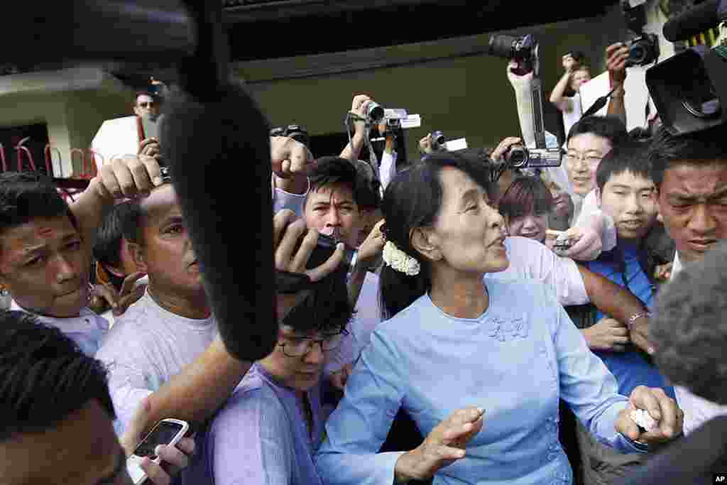 缅甸民主运动领袖昂山素季（右）2012年4月22日参加全国民盟党在仰光举行的会议之后离开办公室。