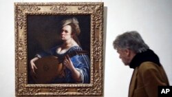 A visitor admires the "Self-Portrait as a Lute Player" painting by Italian 17th century artist Artemisia Gentileschi, at Rome's Braschi Palace museum, Nov. 29, 2016. X-rays of one of Genteleschi's paintings at the Uffizi in Florence have uncovered a self-portrait of the artist.