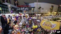 FILE - Fans gather at a memorial for Kobe Bryant in front of Staples Center in Los Angeles, Feb. 2, 2020. 