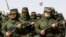 FILE - Sahrawi women soldiers carry their weapons during a parade at the Awserd refugee camp in Tindouf, Algeria, Feb. 27, 2021.