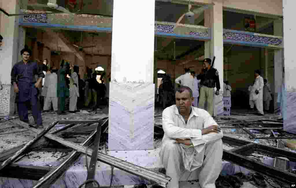A man sits at a Shi'ite mosque targeted by a suicide bomber in Peshawar, Pakistan, June 21, 2013. 