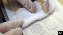 FILE - Slides are prepared during a breast and cervical cancer screening program at the NorthPoint Health and Wellness Center in Minneapolis, Minn.