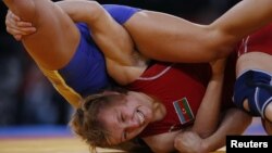 Atlet gulat Azerbaijan Yuliya Ratkevich melawan Valeriia Zholobova dari Rusia dalam pertandingan gulat perempuan Olimpiade 2012. (Reuters/Suhaib Salem)