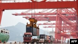 A crane loads a container onto a truck at Lianyungang Port in Lianyungang in China's eastern Jiangsu province on September 7, 2021.