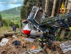 A photo taken and handed out May 23, 2021, by the Italian Firefighters "Vigili del Fuoco" shows rescuers by a cable car that crashed to the ground in the resort town of Stresa on the shores of Lake Maggiore in the Piedmont region.