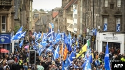 Pro-independence activists wave Scottish Saltire flags as they march in Edinburgh, Scotland, Oct. 5, 2019.
