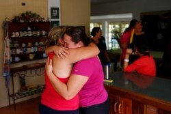 FILE - Natalie Pereira, center, cries as she embraces her sister-in-law before her move to the U.S. after winning the green-card lottery, at their home in Valencia, Venezuela, April 6, 2014.