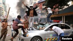 Bangladesh Nationalist Party activists vandalize a police vehicle during clashes in Dhaka, Nov. 14, 2018.