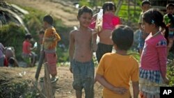 A boy shows small fish in a bottle he caught in a paddy field at Je Yang IDP camp, where 8,000 people have been living after they fled from their villages since June 2011, near the town of Laiza, in Kachin-controled region, February 1, 2013. 