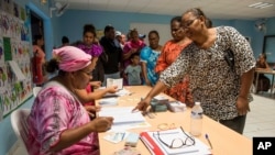 A woman points to a voting notebook before voting in Noumea, New Caledonia, Oct.4, 2020. 