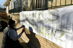 FILE - A supporter of former Illinois Gov. Rod Blagojevich makes a sign thanking President Donald Trump at the Blagojevich home in Chicago, Feb. 18, 2020.