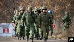 Russia-backed separatist rebels' unit walk to take their position at the new line of contact outside Petrivske, Ukraine, Nov. 9, 2019. 