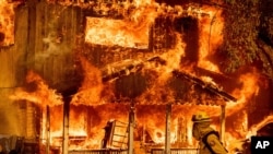 شعله ‌ور شدن خانه‌ای از نتیجه اتش‌سوزی های جنگلی در شهرک روستایی دویل، کالیفرنیا