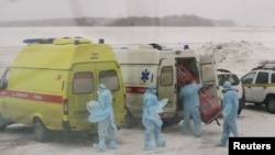 Personal médico ruso prepara transporte para pasajeros de un avión militar que evacuó ciudadanos rusos y de exnaciones soviéticas de la provincia china de Wuhan, epicentro de un brote de coronavirus. Foto: Yuri Shestak/Vsluh.ru/Handout via REUTERS