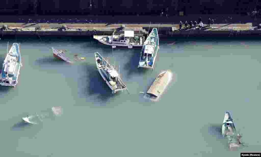 An aerial view shows capsized boats believed to be affected by the tsunami caused by an underwater volcano eruption on the island of Tonga at the South Pacific, in Muroto, Kochi prefecture, Japan.