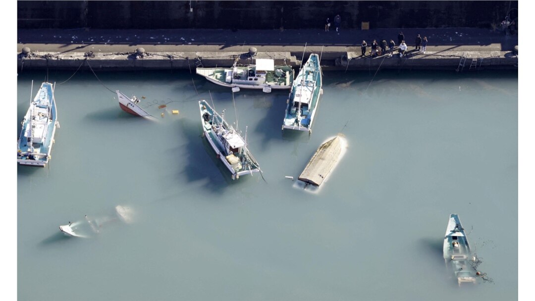 FILE - An aerial view shows capsized boats believed to be affected by the tsunami caused by an underwater volcano eruption on the island of Tonga at the South Pacific, in Muroto, Kochi prefecture, Japan, in this photo taken by Kyodo Jan. 16, 2022.